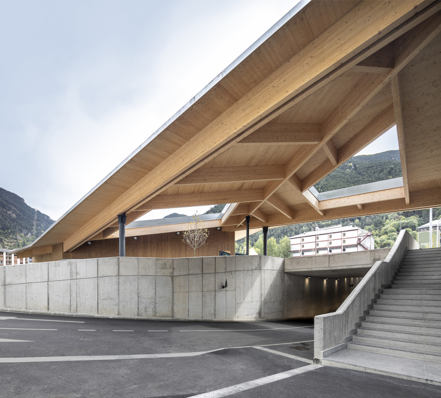 viaducte soterrat que travessa el parc cobert amb porxo de fusta que dona contiunuitat a l edifici